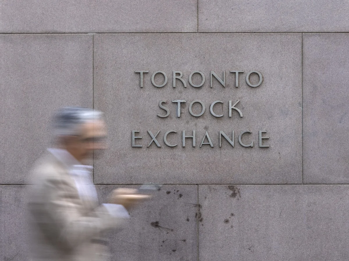 A pedestrian walks past Toronto Stock Exchange signage in Toronto’s Financial District.